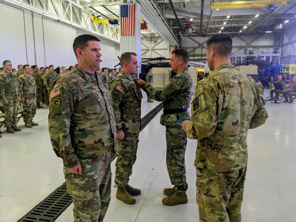 Ohio Army National Guard Brig. Gen. Stephen Rhoades (center), commander of Special Troops Command (Provisional), pins the Purple Heart medal on Sgt. Tristan Meyers during a ceremony at the Army Aviation Support Facility #1 in Green. Meyers was among U.S. service members injured during a missile attack Jan. 8, 2020, at Al Asad Airbase, Iraq.