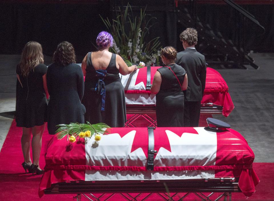 <p>Jackie McLean, accompanied by their children, places a rose on the casket for her husband, Const. Robb Costello, at the regimental funeral for Costello and Const. Sara Burns, killed in the line of duty, in Fredericton on Saturday, Aug. 18, 2018. The two city police officers were among four people who died in a shooting in a residential area on the city’s north side. (Photo from The Canadian Press/Andrew Vaughan) </p>