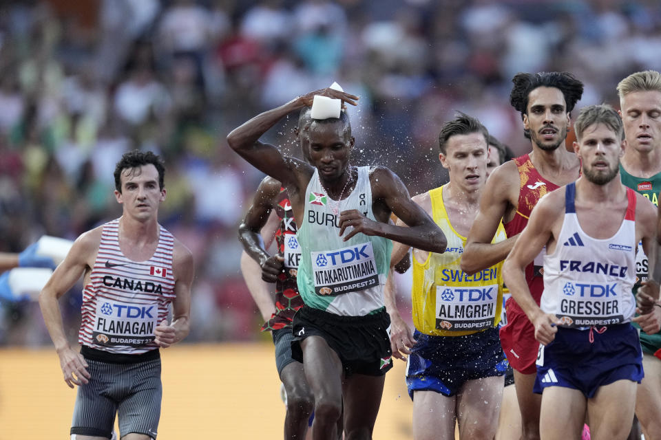 FILE - Egide Ntakarutimana, of Burundi, squeezes a sponge with water over himself while running in a Men's 5000-meters heat during the World Athletics Championships in Budapest, Hungary, Thursday, Aug. 24, 2023. (AP Photo/Bernat Armangue, File)