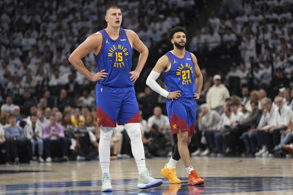 Denver Nuggets center Nikola Jokic (15) and guard Jamal Murray (27) stand on the court during the first half of Game 3 of an NBA basketball second-round playoff series against the Minnesota Timberwolves, Friday, May 10, 2024, in Minneapolis. (AP Photo/Abbie Parr)