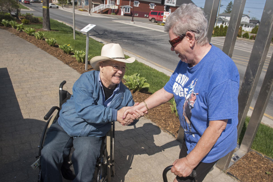 Ron Turcotte shakes the hand of fan Rolande Bosse in Grand Falls, New Brunswick, Canada, on Wednesday, May 31, 2023. From a tiny village in New Brunswick, Turcotte rose to the heights of the horse racing world, riding Secretariat to a sweep of the Kentucky Derby, Preakness and Belmont in 1973. (AP Photo/Stephen MacGillivray)