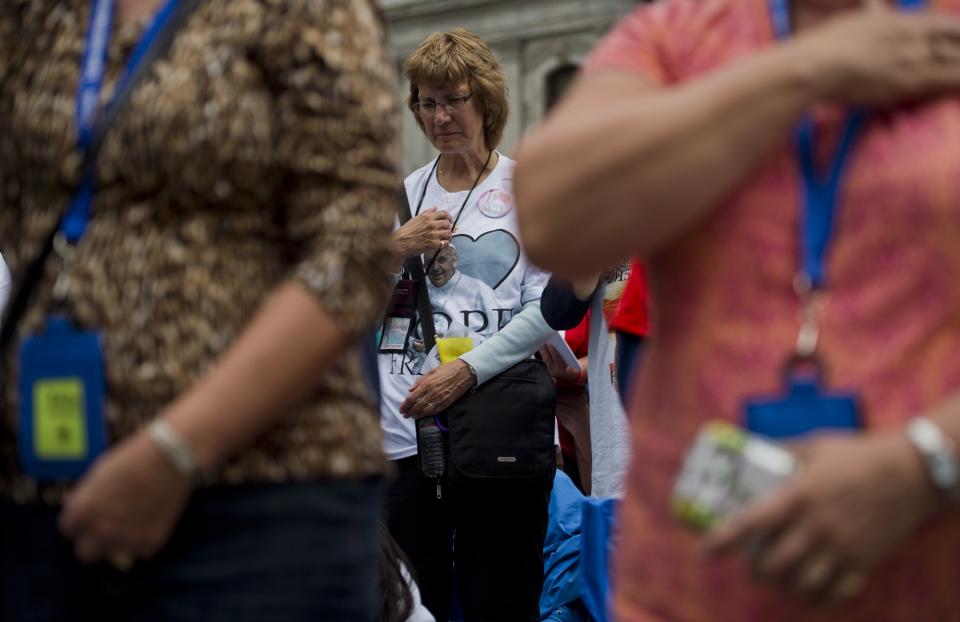 A woman does the sign of the cross as she take part in a Mass with Pope Francis in downtown Philadelphia, Pennsylvania on September 27, 2015. AFP PHOTO/ ANDREW CABALLERO-REYNOLDS        (Photo credit should read Andrew Caballero-Reynolds/AFP/Getty Images)