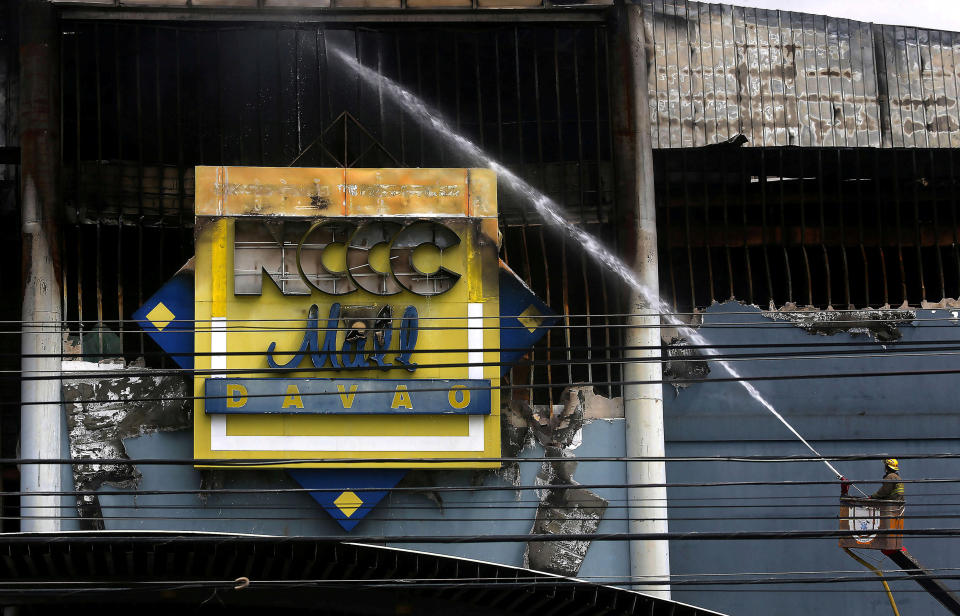 On Sunday, a day after the blaze began, firefighters were still unable to enter the still-smouldering building. (Photo: Marconi Navales / Reuters)