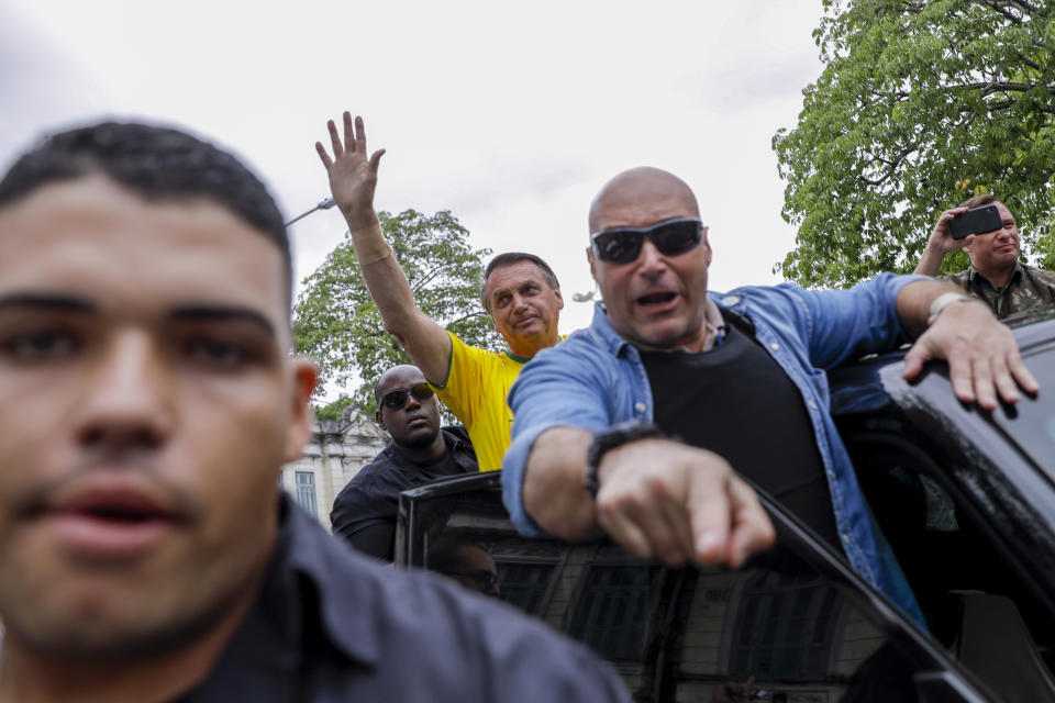 Brazil's President Jair Bolsonaro, who is running for another term, waves as he drives away from a polling station after voting in general elections in Rio de Janeiro, Brazil, Sunday, Oct. 2, 2022. (AP Photo/Bruna Prado)