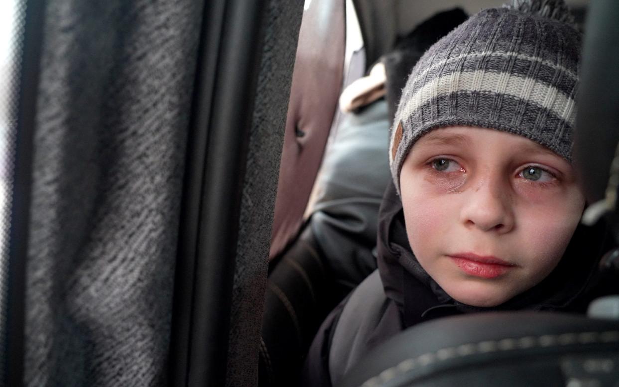  Mark Goncharuk, a young boy from Kyiv, reacts as he talks about leaving his father behind as he travels with the rest of his family towards the border, following Russia's invasion of Ukraine - NATALIE THOMAS/ REUTERS