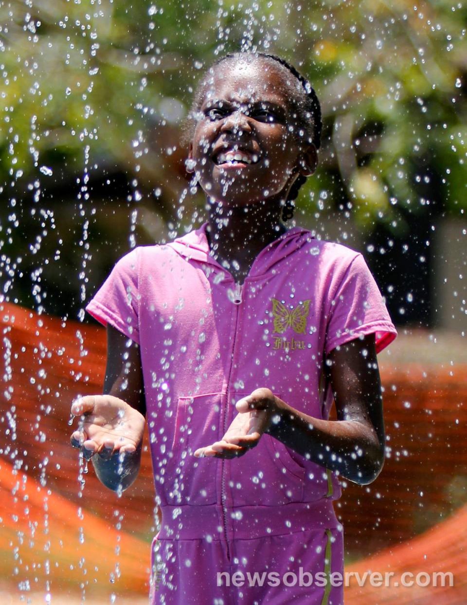 Janiya Bobbitt, 7, feels the cooling water of a vertical sprayer Friday afternoon, July 1, 2011 at the Forest Hills Park spray grounds in Durham, N.C. The city hopes to build new aquatic parks with bond money they’ll ask voters to approve in November 2024.