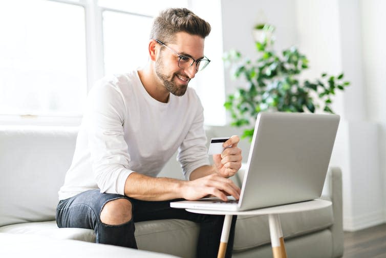 Image of a man sitting in front of his laptop.