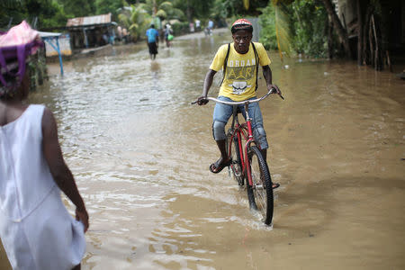 A man rides a bicycle in a flooded area after Hurricane Irma in Fort Liberte, Haiti, September 8, 2017. REUTERS/Andres Martinez Casares