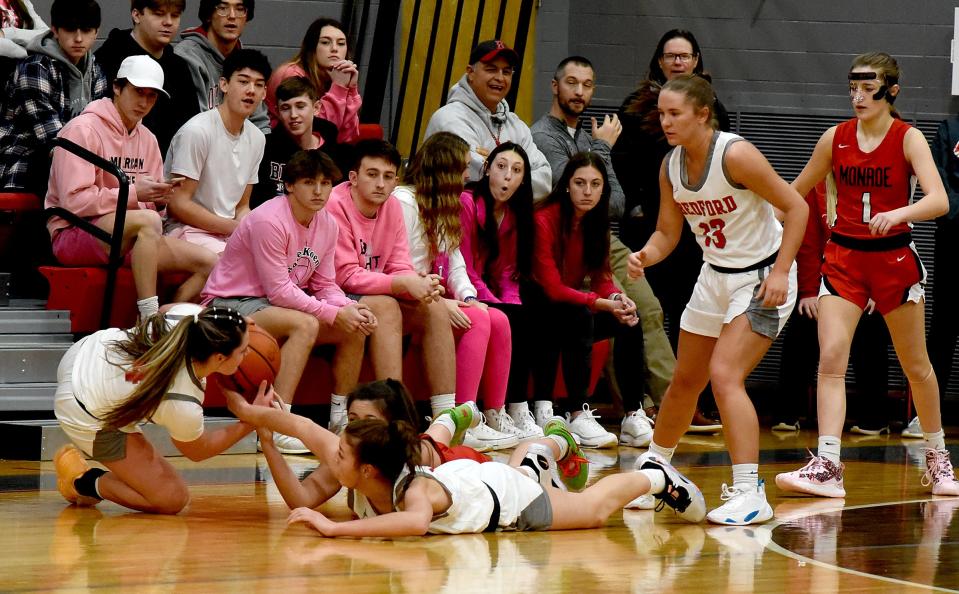 Sophia Bussell of Monroe scrambles for the ball with Peyton Behnke and Victoria Gray of Bedford Friday night. Bedford won 50-20.