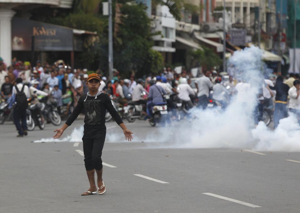 A protester supporting the opposition Cambodia National Rescue Party (CNRP) reacts as police fire tear gas during clashes near the Royal Palace in central Phnom Penh September 15, 2013. (REUTERS/Samrang Pring)