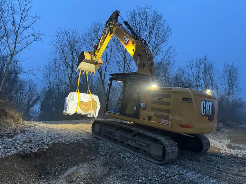 A construction vehicle moves the ancient Roman artifact.