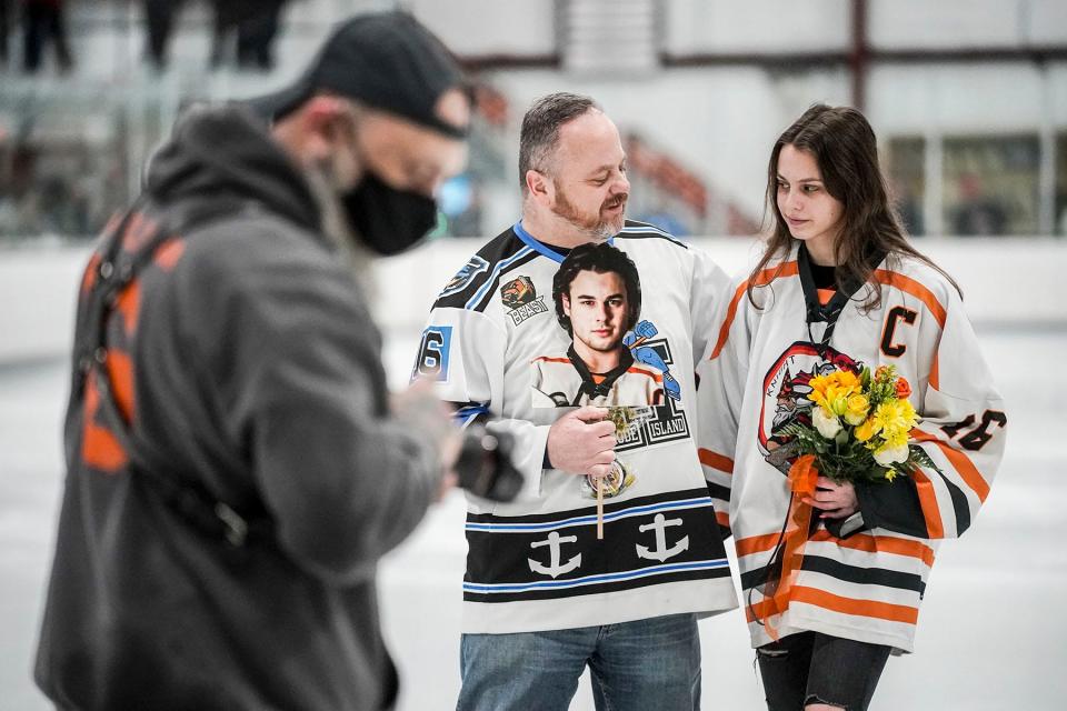 Matt Dennison’s father, Mark, and his sister, Katie, walk off the ice after a ceremony honoring seniors before a Feb. 18 game in West Warwick.