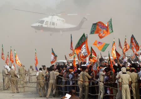 Police try to hold back supporters of Hindu nationalist Narendra Modi, prime ministerial candidate for the BJP, as he arrives in a chopper to address an election campaign rally in Allahabad May 4, 2014. REUTERS/Jitendra Prakash