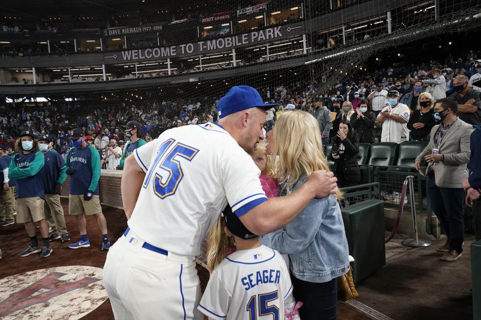 Seattle Mariners third baseman Kyle Seager (15) kisses his wife Julie Seager after a baseball game against the Los Angeles Angels Sunday, Oct. 3, 2021, in Seattle. The Angels won 7-3. The game was potentially Seager's final game. (AP Photo/Elaine Thompson)