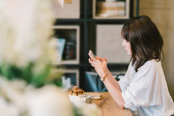 A young woman uses a smartphone.