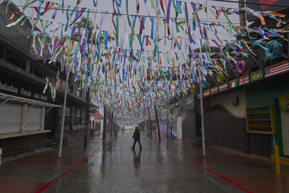 Un hombre cruza una calle tras la llegada a tierra de la tormenta tropical Hilary en Rosarito, México, el 20 de agosto de 2023. Hilary azotó la costa en una zona poco poblada a unos 250 kms (150 millas) al sur de Ensenada, México. (AP Foto/Alejandro Cossio)