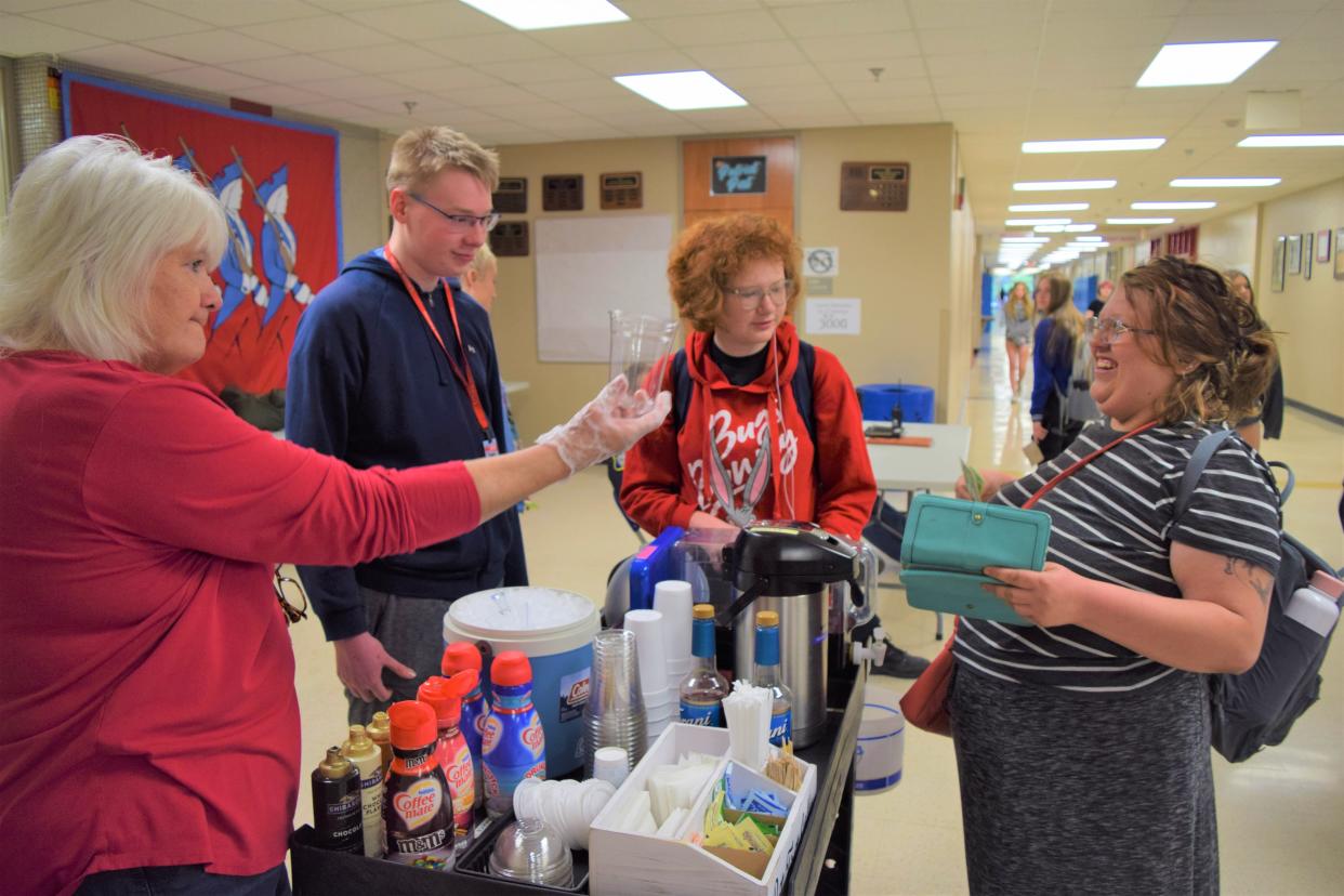 From left to right: Cassia Oaks, an education assistant; Kaden Kittamus and Rhonda Lambert, both freshmen at Lincoln High School, serve a coffee to LHS senior Randa LaRue on May 20, 2022.