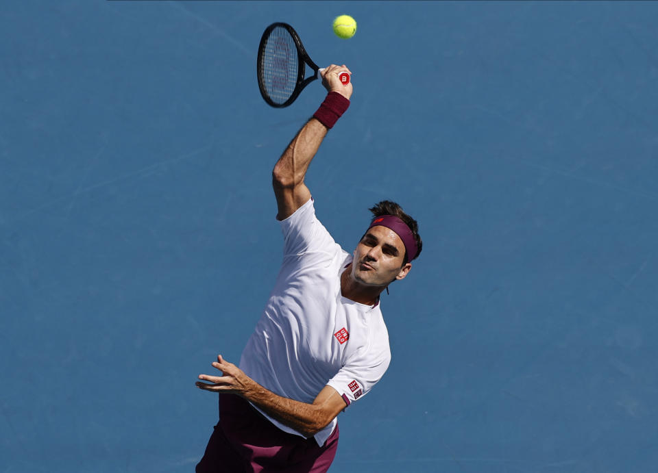 Switzerland's Roger Federer makes a forehand return to Tennys Sandgren of the U.S. during their quarterfinal match at the Australian Open tennis championship in Melbourne, Australia, Tuesday, Jan. 28, 2020. (AP Photo/Andy Wong)