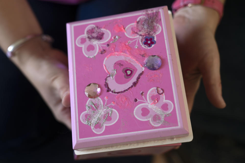 Jessica Riester Hart holds a jewelry box decorated by her daughter, 5-year-old Allie Hart, who was struck and killed in 2021 by a driver while riding her bicycle in a crosswalk near their home, Thursday, Sept. 14, 2023, in Washington. (AP Photo/Mark Schiefelbein)