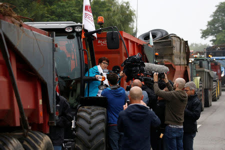 Christiane Lambert, President of France's farmer's union group FNSEA, talks to journalists as she stands on a tractor during a protest by French farmers to block the French oil giant Total refinery in Donges, France, June 11, 2018. REUTERS/Stephane Mahe