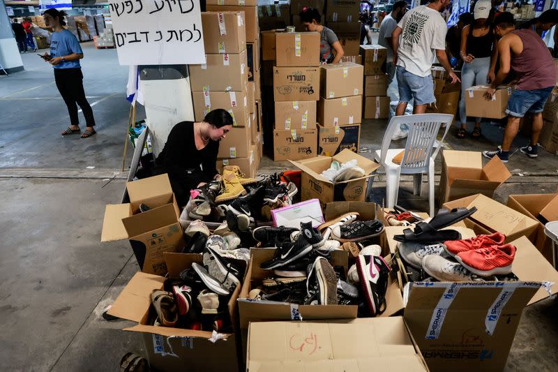 Volunteers pack boxes of donated humanitarian supplies at a logistical centre to support those impacted by the deadly infiltration by Hamas gunmen from the Gaza Strip, in Tel Aviv