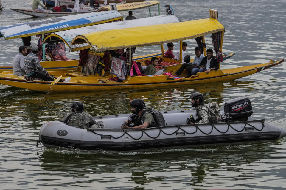 Tourists enjoy boat ride as Indian Navy's Marine Commandos patrol the Dal Lake ahead of G20 tourism working group meeting in Srinagar, Indian controlled Kashmir, Wednesday, May 17, 2023. Indian authorities have stepped up security and deployed elite commandos to prevent rebel attacks during the meeting of officials from the Group of 20 industrialized and developing nations in the disputed region next week. (AP Photo/Mukhtar Khan)
