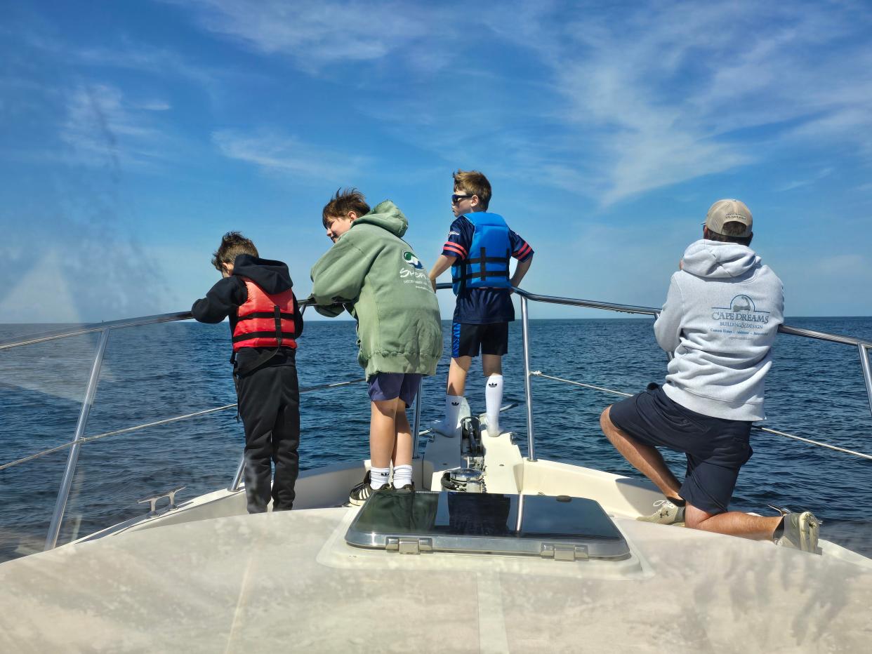 Watching an orca during their tuna fishing outing aboard the Cameron William on June 2 are, from left, Elliot Van Buren, 8, Cameron van Steensel, 8, Connor van Steensel, 7, and Chuck Van Buren.