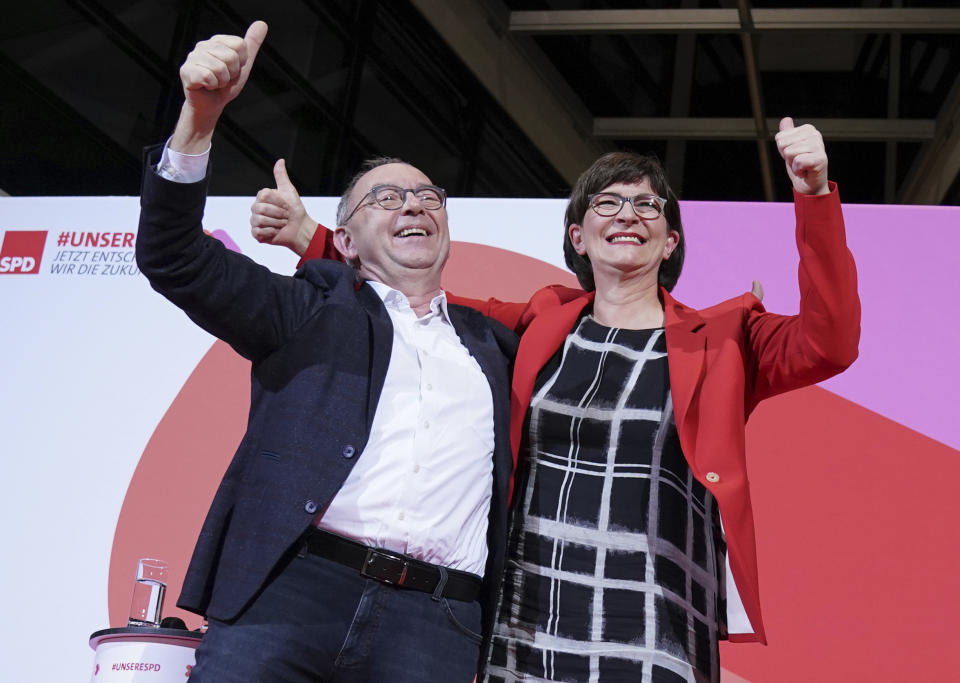 Norbert Walter-Borjans and Saskia Esken wave after the announcement of the result of the vote on the SPD chairmanship in the Willy Brandt House in Berlin, Germany, Saturday, Nov. 30, 2019. Walter-Borjans and Esken have won the vote. The new leadership will be confirmed at the party conference on December 6. (Kay Nietfeld/dpa via AP)