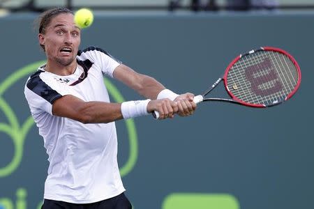 Novak Djokovic hits a backhand against Alexandr Dolgopolov (not pictured) on day nine of the Miami Open at Crandon Park Tennis Center. Djokovic won 6-7 (3), 7-5, 6-0. Mandatory Credit: Geoff Burke-USA TODAY Sports