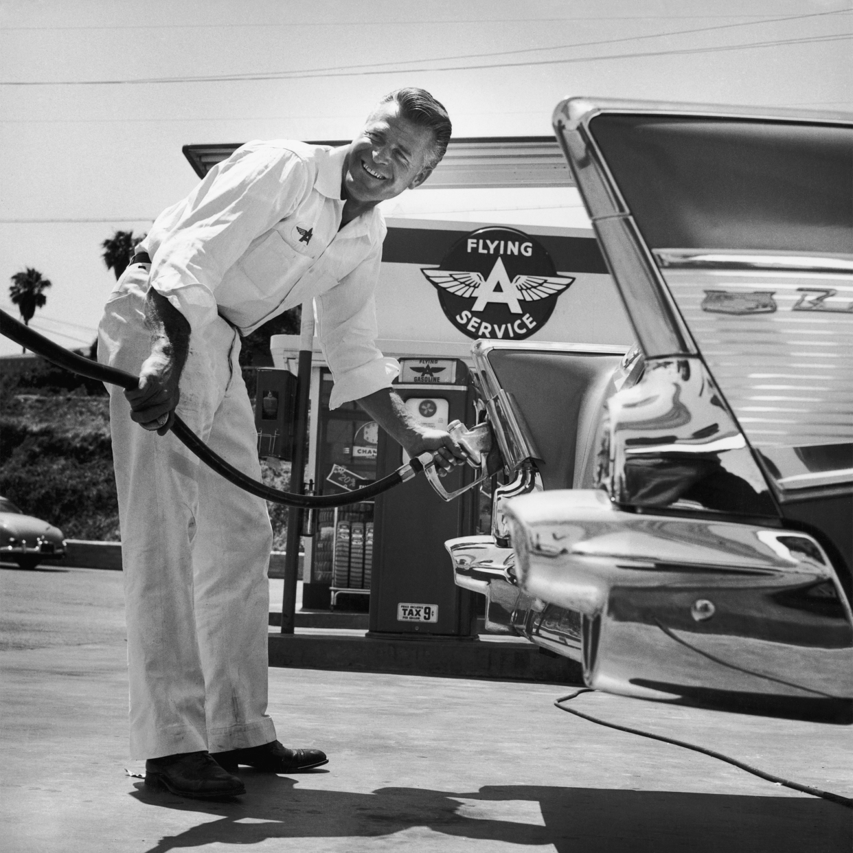 A petrol pump attendant filling up a car at a Flying A service station.