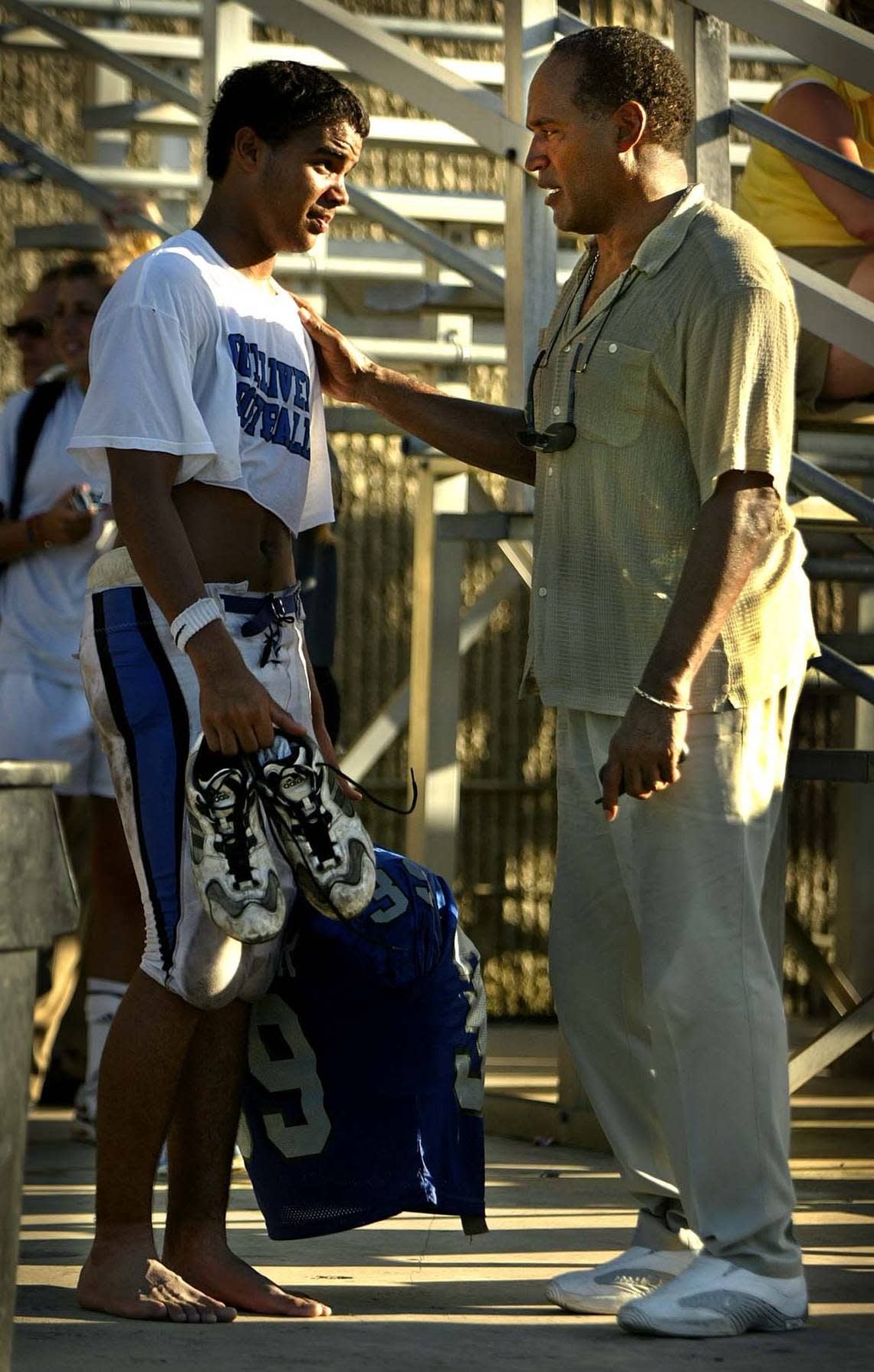 In 2002, Gulliver Prep football player Justin Simpson talks with his father, O.J. Simpson after the team defeated Archbishop Curley High School in Miami. Al Diaz/Miami Herald File