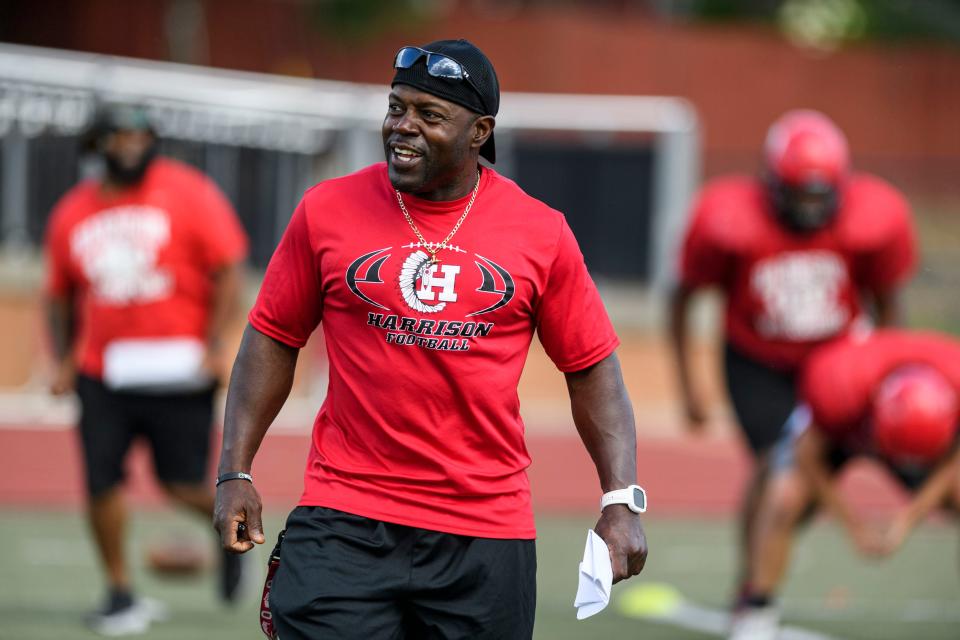 Harrison High School's head football coach Moe Sutton laughs as he watches his players run conditioning drills during an afternoon practice at Romain Stadium in Evansville, Ind., Wednesday, Aug. 4, 2021.