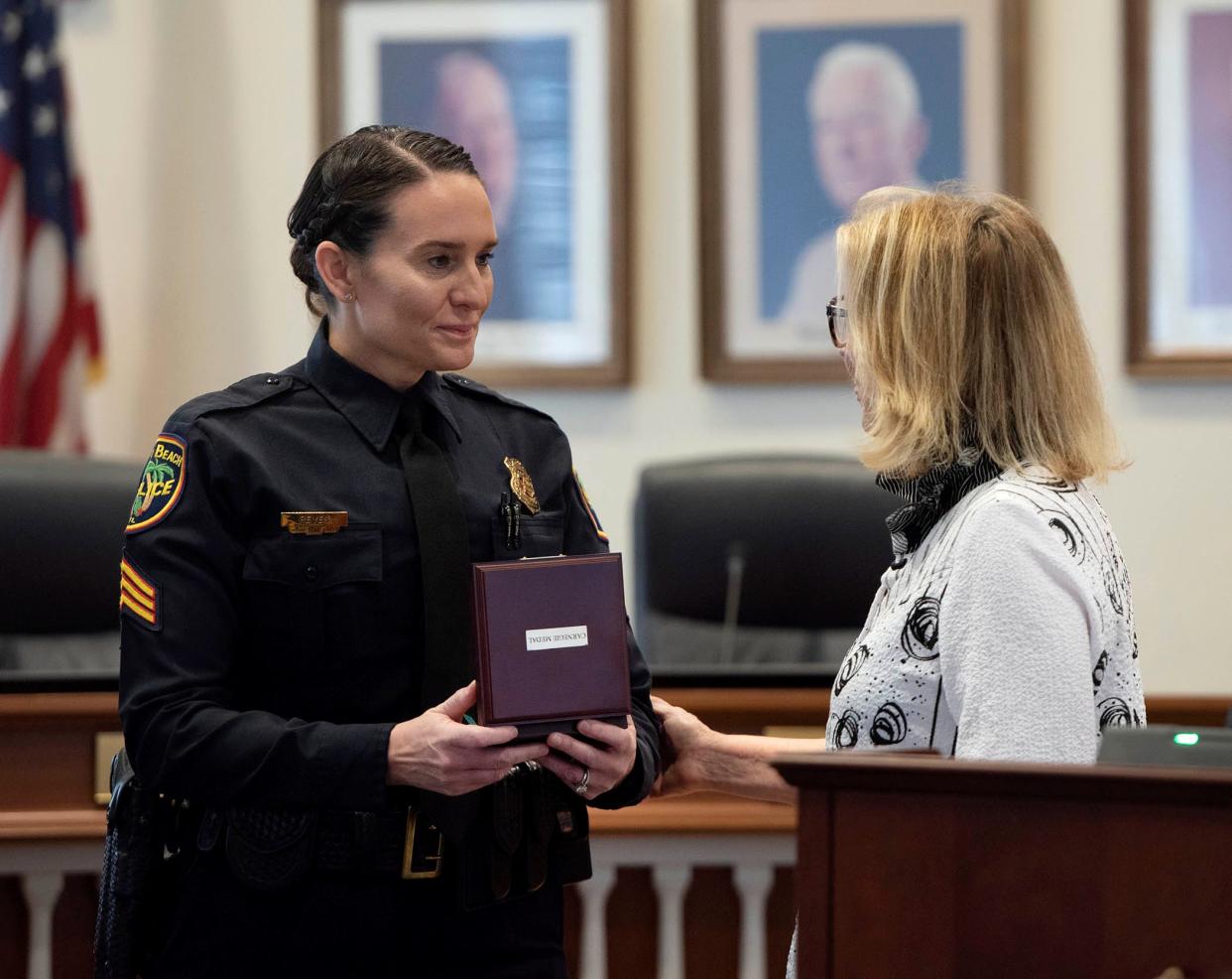 Nancy Rackoff, right, presents Palm Beach Police Sgt. Kendall Reyes with the Carnegie Medal during the police department promotional and awards ceremony at Town Council chambers Friday.
