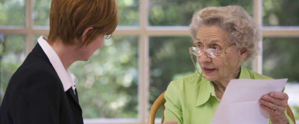 Mature woman talking to financial planner at home