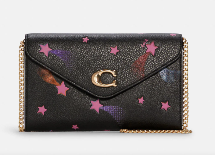 Tammie Clutch Crossbody in black and pink star print (Photo via Coach Outlet)