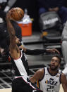 Los Angeles Clippers guard Paul George, left, dunks as Utah Jazz center Rudy Gobert watches during the second half of Game 3 of a second-round NBA basketball playoff series Saturday, June 12, 2021, in Los Angeles. (AP Photo/Mark J. Terrill)