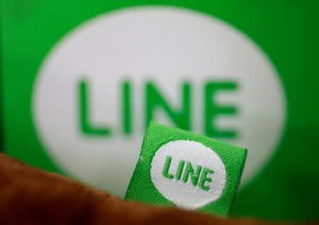 The logo of free messaging app Line is pictured on a smartphone and the company's stuffed toy in this photo illustration taken in Tokyo, Japan, September 23, 2014. REUTERS/Toru Hanai/Illustration/File Photo
