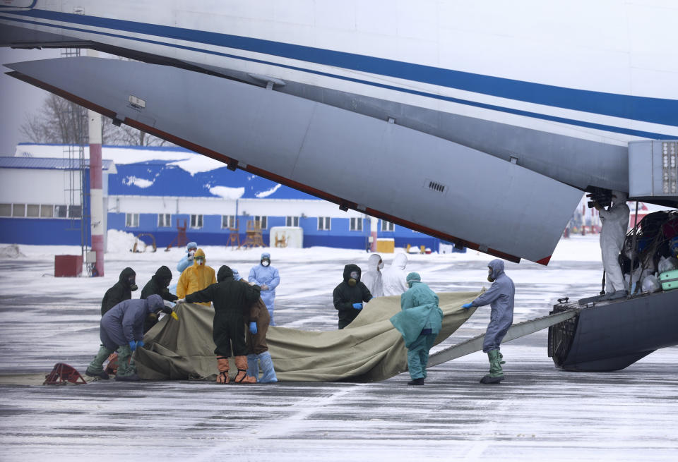 A group of medical personnel prepare to meet 80 people, accompanied by medical specialists, carried by a Russian military plane at an airport outside Tyumen, Russia, Wednesday, Feb. 5, 2020. Russia has evacuated 144 people, Russians and nationals of Belarus, Ukraine and Armenia, from the epicenter of the coronavirus outbreak in Wuhan, China, on Wednesday. All evacuees will be quarantined for two weeks in a sanatorium in the Tyumen region in western Siberia, government officials said. (AP Photo/Maxim Slutsky)