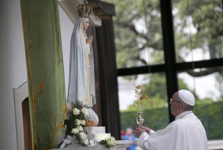 Pope Francis offers a golden rose to the statue of Our Lady of Fatima at the Chapel of the Apparitions at the Shrine of Our Lady of Fatima in Portugal May 12, 2017. REUTERS/Tony Gentile