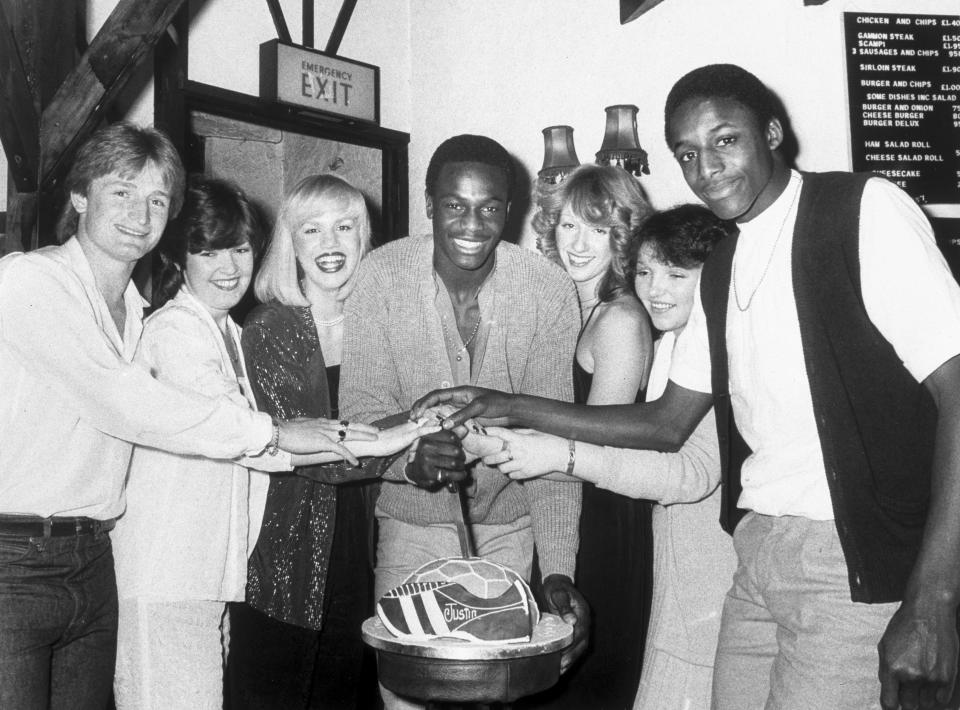 UNITED KINGDOM - FEBRUARY 26:  Justin Fashanu (1961-1998) (centre) about to cut his birthday cake, which is shaped like a football boot and football. His brother John Fashanu is shown far right. Justin made his professional debut for Norwich City in 1979 and became Britain�s first million pound black footballer when he moved to Nottingham Forest in 1981. In 1990 he come out as a homosexual and committed suicide in 1998.  (Photo by SSPL/Getty Images)