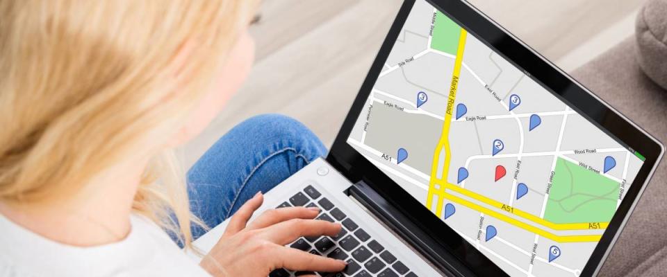 Close-up Of A Woman Using GPS Map With Navigation Pointers On Laptop