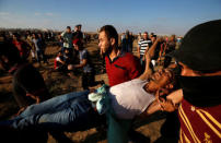A wounded Palestinian is evacuated during a protest demanding the right to return to their homeland at the Israel-Gaza border, in Gaza August 17, 2018. REUTERS/Mohammed Salem