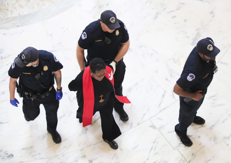A minister belonging to a group demanding that Congress to reject the Trump administration's budget proposals and health care bill is arrested during a demonstration in the Russell Senate Building on Capitol Hill in Washington on July 18, 2017. (Photo: Manuel Balce Ceneta/AP)