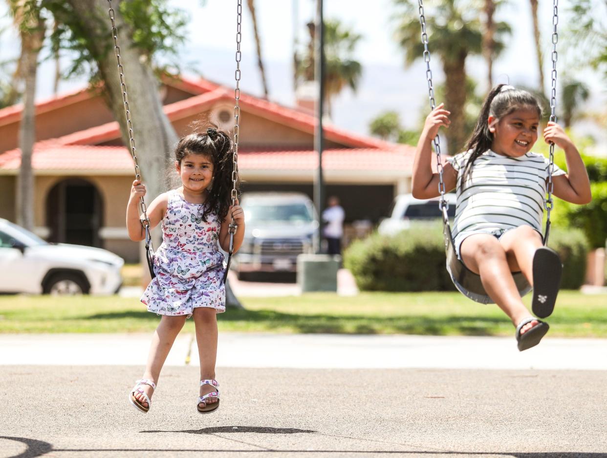 Cousins Lola, 5, (left) and Drea, 7, swing together at Panorama Park in Cathedral City, Calif., Monday, April 25, 2022.