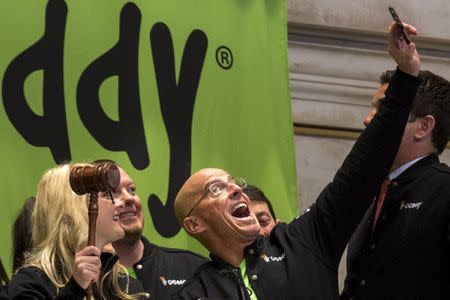 GoDaddy Chief Executive Officer Blake Irving takes a "selfie" photo with a customer before they ring the opening bell to celebrate his web hosting company GoDaddy's IPO on the floor of the New York Stock Exchange April 1, 2015. REUTERS/Brendan McDermid