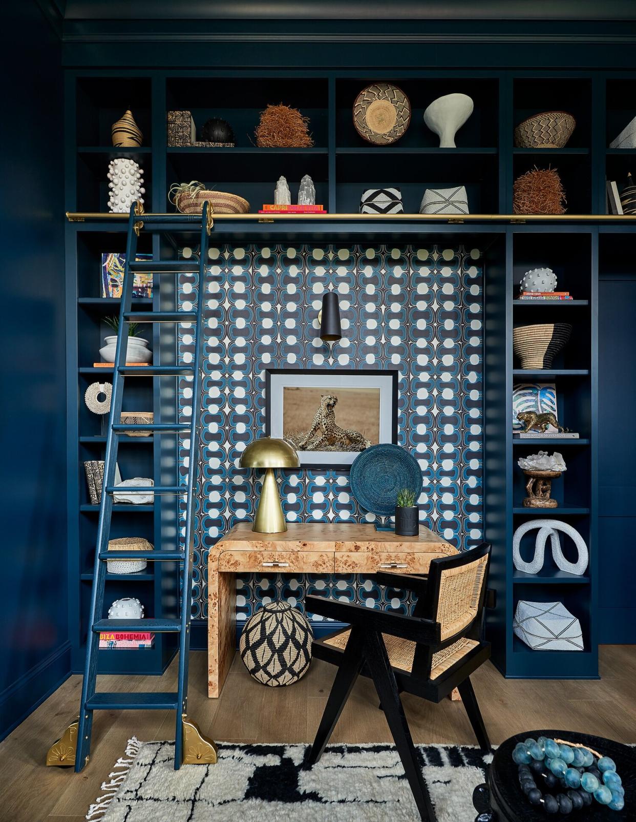 Dark blue home office with shelves and a burl wood desk