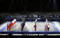 Gymnasts from four countries China, from left, U.S., Japan and Russia line up for the opening ceremony of an international gymnastics meet in Tokyo on Sunday, Nov. 8, 2020. The postponed Tokyo Olympics are to open in just under nine months. The International Olympic Committee and Japanese organizers have unwavering support from Japan’s ruling party and Tokyo’s municipal government. But there is a tiny murmur of resistance to the Olympic behemoth. A few voices in the national legislature question the wisdom of holding the Olympics in a pandemic. (AP Photo/Hiro Komae)