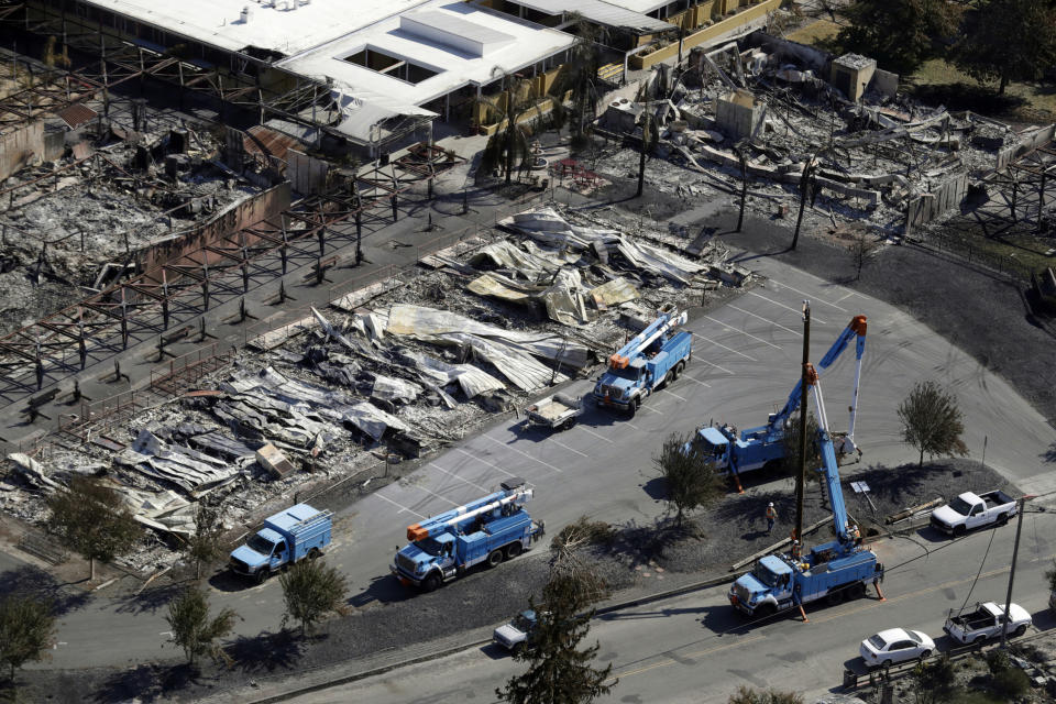 FILE - In this Oct. 14, 2017, file photo, Pacific Gas & Electric crews work on restoring power lines in a fire ravaged neighborhood in the aftermath of a wildfire in Santa Rosa, Calif. California Gov. Gavin Newsom's opposition to PG&E's restructuring plan just a week after it struck a $13.5 billion settlement with fire victims is forcing the nation's largest utility to go back to the negotiating table and come up with a solution fairly quickly. (AP Photo/Marcio Jose Sanchez, File)