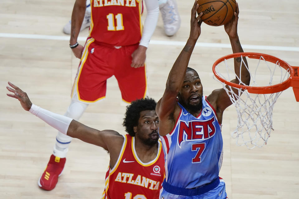 Brooklyn Nets forward Kevin Durant (7) shoots next to Atlanta Hawks' Solomon Hill during the first half of an NBA basketball game Wednesday, Jan. 27, 2021, in Atlanta. (AP Photo/Brynn Anderson)