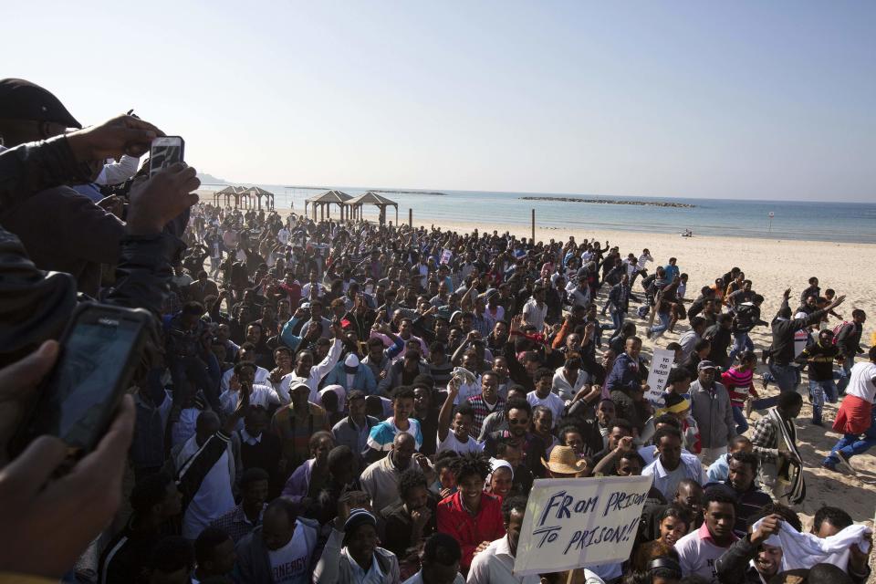 African migrants run on a beach during a protest near the U.S. embassy in Tel Aviv January 6, 2014. Several thousand African migrants protested outside Western embassies in Tel Aviv on Monday, demanding freedom for compatriots jailed by Israel in a desert facility under a new open-ended detention law. REUTERS/Baz Ratner (ISRAEL - Tags: POLITICS SOCIETY IMMIGRATION CIVIL UNREST)